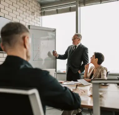 Consultant facilitating a discussion with a leadership team during a working session.